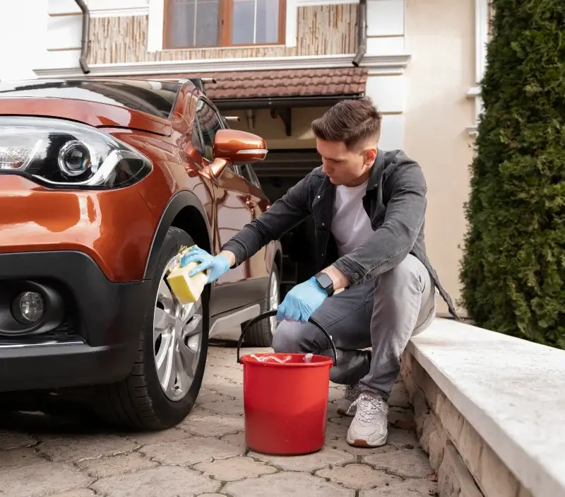 Lavage auto à domicile Sévigny-la-Forêt : professionnel intervenant sur un véhicule